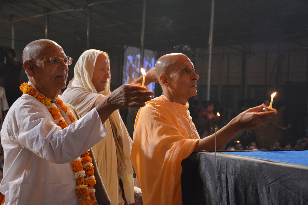 Radhanath Swami and Senior devotees offering lamps to Lord Damodar